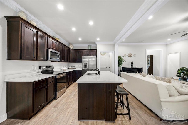 2219 River Birch Rd, Gulf Breeze, FL 32563 - kitchen with stainless steel appliances, open floor plan, a sink, crown molding, and a breakfast bar