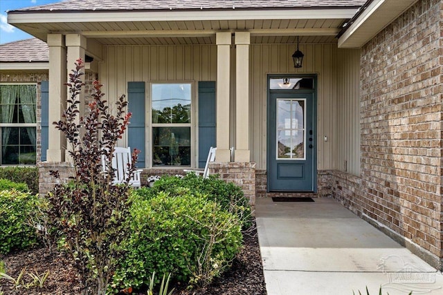 2219 River Birch Rd, Gulf Breeze, FL 32563 - property entrance with roof with shingles, a porch, and brick siding