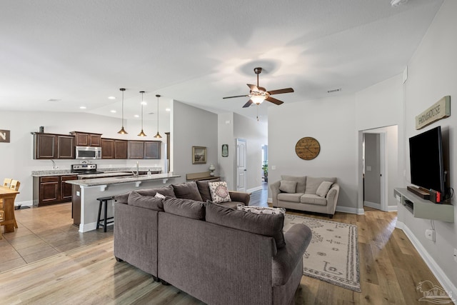 5613 Cane Syrup Cir, Pace, FL 32571 - living area featuring vaulted ceiling, ceiling fan, baseboards, and light wood finished floors
