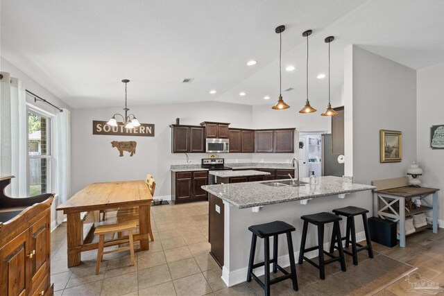 5613 Cane Syrup Cir, Pace, FL 32571 - kitchen with appliances with stainless steel finishes, a sink, lofted ceiling, a kitchen bar, and dark brown cabinets