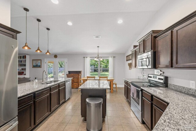 5613 Cane Syrup Cir, Pace, FL 32571 - kitchen featuring stainless steel appliances, a sink, dark brown cabinets, light stone countertops, and hanging light fixtures