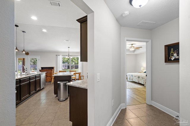 5613 Cane Syrup Cir, Pace, FL 32571 - kitchen with a sink, stainless steel dishwasher, light tile patterned floors, a center island, and light stone counters