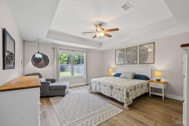 5613 Cane Syrup Cir, Pace, FL 32571 - bedroom featuring a tray ceiling, wood finished floors, baseboards, and ceiling fan