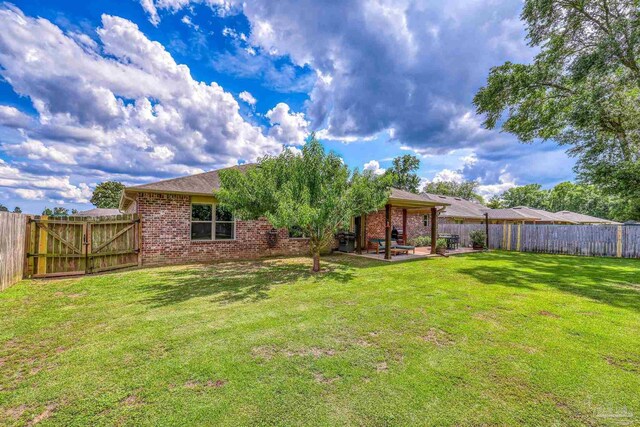 5613 Cane Syrup Cir, Pace, FL 32571 - rear view of house featuring a patio area, brick siding, and a gate