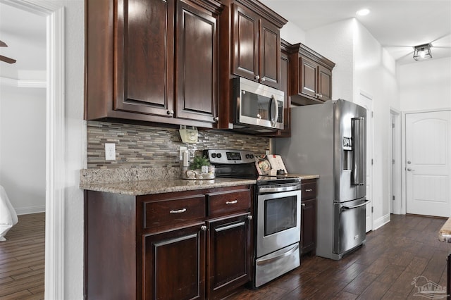 kitchen with tasteful backsplash, light stone countertops, dark hardwood / wood-style floors, and appliances with stainless steel finishes