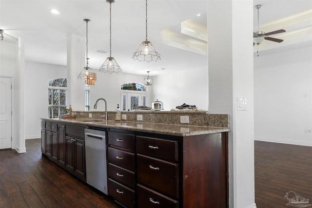 kitchen with pendant lighting, dark hardwood / wood-style floors, light stone countertops, and sink