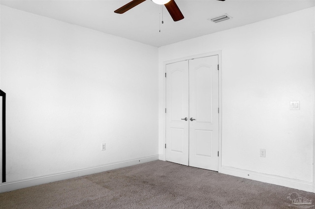 unfurnished bedroom with carpet floors, a closet, and ceiling fan