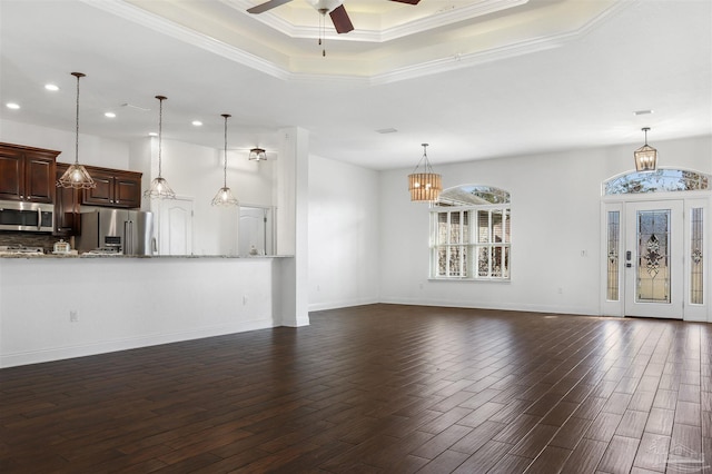 unfurnished living room with crown molding, dark hardwood / wood-style flooring, a raised ceiling, and ceiling fan with notable chandelier