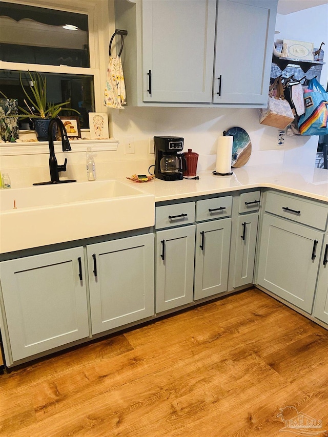 7453 Northpointe Blvd, Pensacola, FL 32514 - kitchen with a sink, gray cabinetry, light countertops, and light wood-type flooring