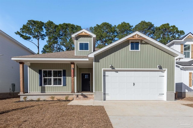 view of front of house with a garage, covered porch, a shingled roof, concrete driveway, and board and batten siding