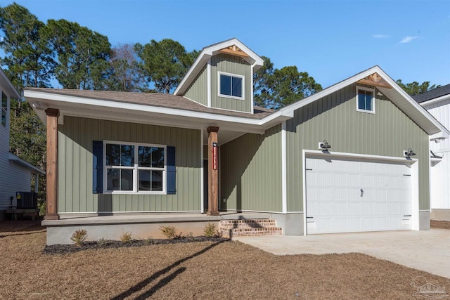 view of front of house with roof with shingles, central air condition unit, covered porch, a garage, and driveway