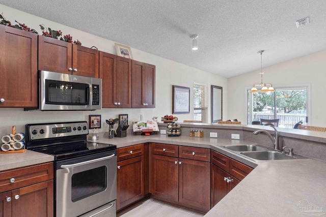 6742 Britt St, Navarre, FL 32566 - kitchen with stainless steel appliances, a sink, vaulted ceiling, a textured ceiling, and light countertops