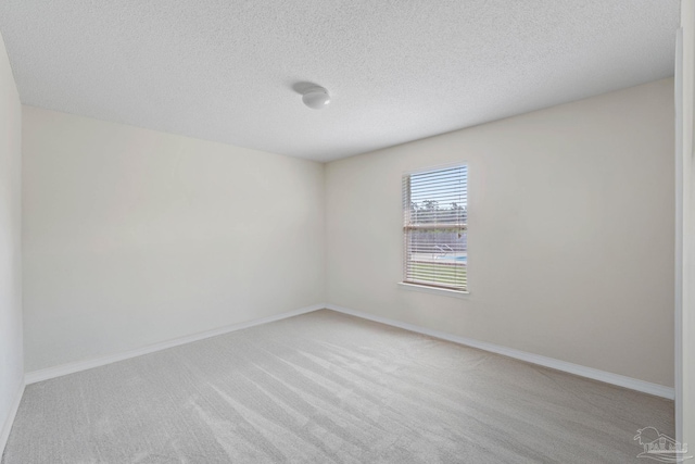 6742 Britt St, Navarre, FL 32566 - spare room with light colored carpet, a textured ceiling, and baseboards