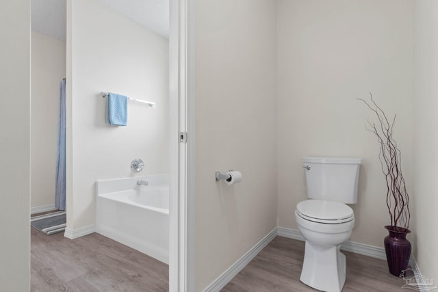 6742 Britt St, Navarre, FL 32566 - full bathroom featuring wood finished floors, toilet, a bath, and baseboards