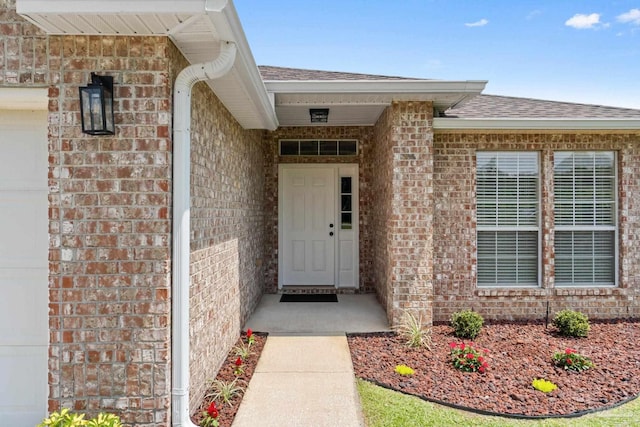 6742 Britt St, Navarre, FL 32566 - doorway to property featuring brick siding and a shingled roof