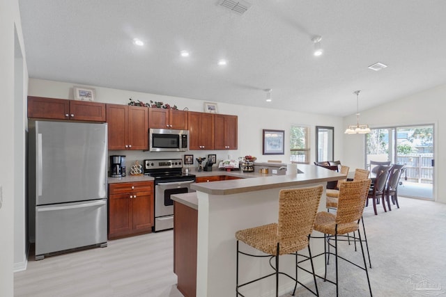6742 Britt St, Navarre, FL 32566 - kitchen featuring appliances with stainless steel finishes, a chandelier, a kitchen breakfast bar, vaulted ceiling, and decorative light fixtures