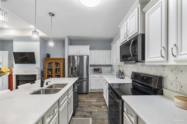 kitchen with electric range, stainless steel refrigerator with ice dispenser, a sink, dark wood-style floors, and white cabinetry