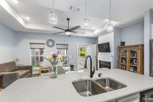 kitchen featuring a sink, open floor plan, a raised ceiling, and recessed lighting