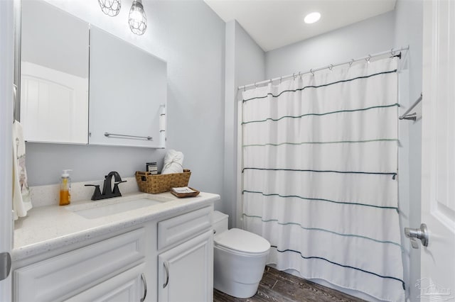 full bath featuring wood finished floors, vanity, toilet, and curtained shower