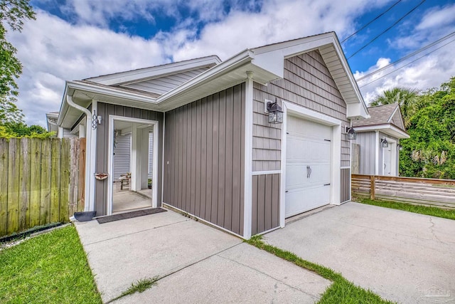 garage featuring fence and driveway