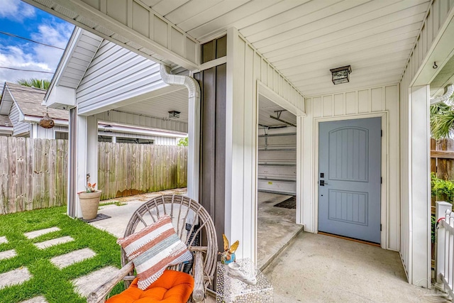 doorway to property with board and batten siding and fence