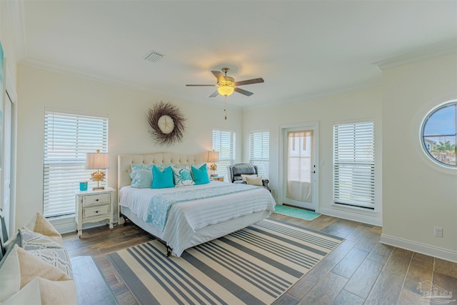 bedroom featuring crown molding, visible vents, multiple windows, and wood finished floors