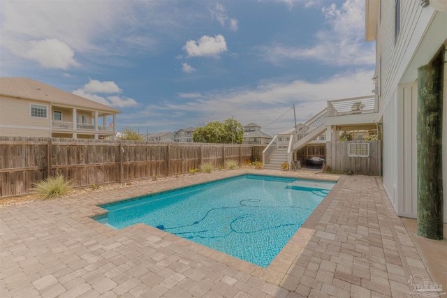 view of swimming pool with a fenced backyard, a fenced in pool, a patio area, and stairway