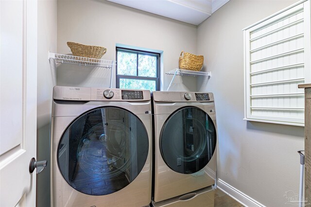 washroom with laundry area, washing machine and dryer, and baseboards