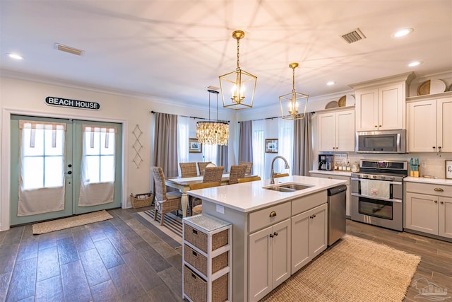 kitchen featuring an inviting chandelier, crown molding, visible vents, a sink, and stainless steel appliances