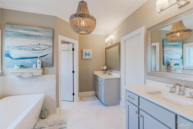 full bath with a sink, a freestanding tub, a chandelier, and ornamental molding