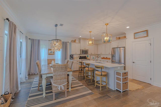 dining area featuring crown molding, a chandelier, and visible vents