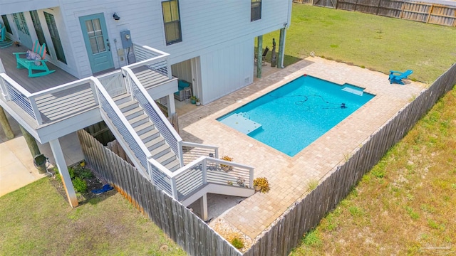 view of pool with a yard, a patio, a fenced backyard, and stairs
