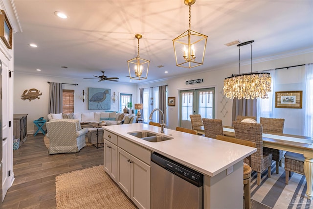 kitchen with stainless steel dishwasher, a sink, a healthy amount of sunlight, and light countertops