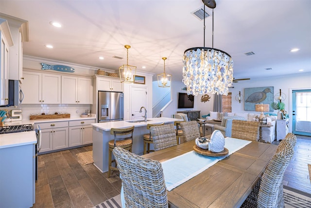 dining space with visible vents, ornamental molding, and dark wood-style flooring