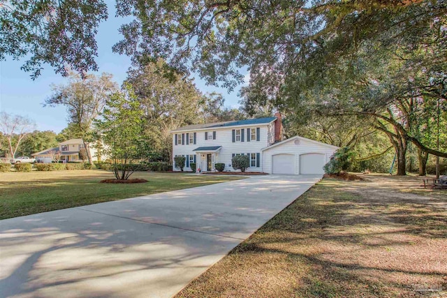 view of front facade with an outbuilding, a front yard, and a garage