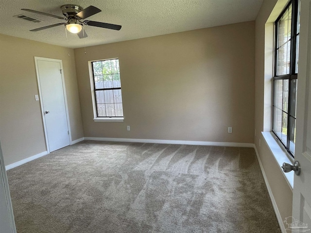 unfurnished room with ceiling fan, carpet, and a textured ceiling