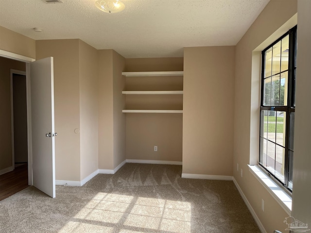 unfurnished bedroom featuring light carpet and a textured ceiling