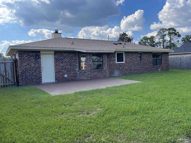 back of house with a patio and a lawn