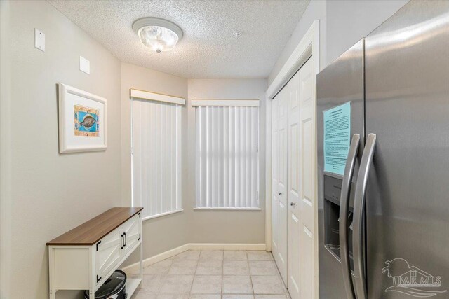 8499 Gulf Blvd Unit 1303, Navarre Beach, FL 32566 - doorway to outside with a textured ceiling and baseboards