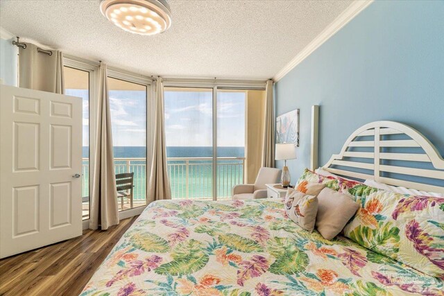 8499 Gulf Blvd Unit 1303, Navarre Beach, FL 32566 - bedroom featuring access to exterior, a textured ceiling, wood finished floors, ornamental molding, and a water view