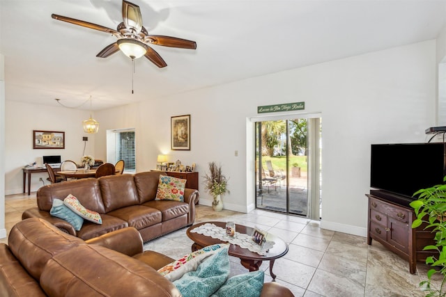 tiled living room with ceiling fan with notable chandelier