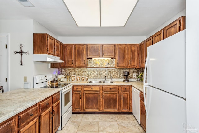 kitchen featuring sink, backsplash, and white appliances