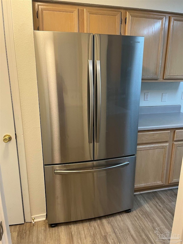 kitchen featuring light brown cabinets, stainless steel refrigerator, and light hardwood / wood-style floors