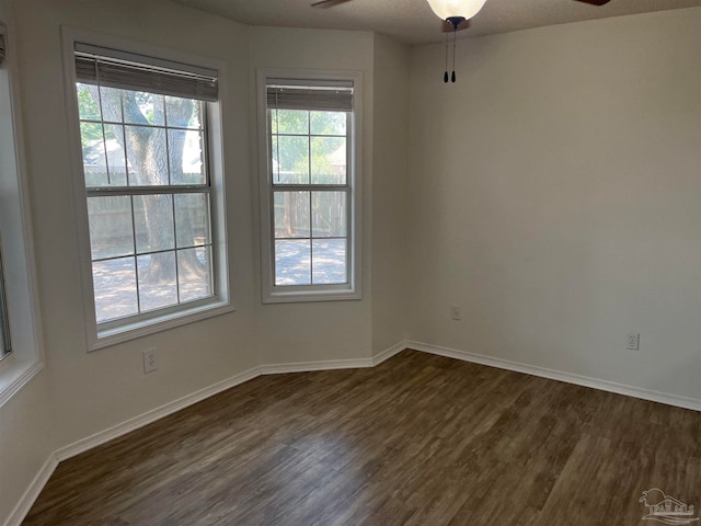 spare room with dark wood-type flooring and ceiling fan