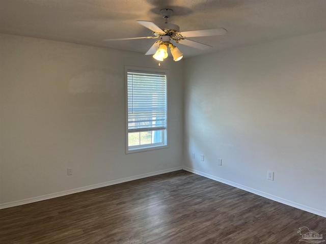 spare room with dark hardwood / wood-style floors and ceiling fan