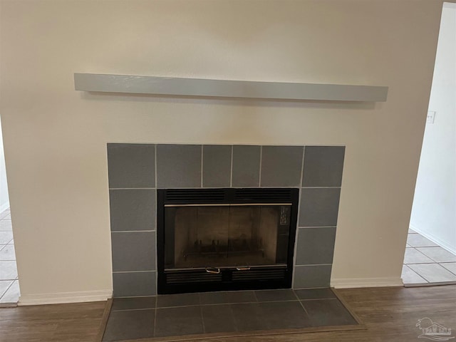 room details with a tile fireplace and hardwood / wood-style floors