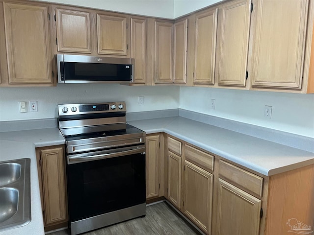 kitchen with light hardwood / wood-style floors, appliances with stainless steel finishes, and light brown cabinetry