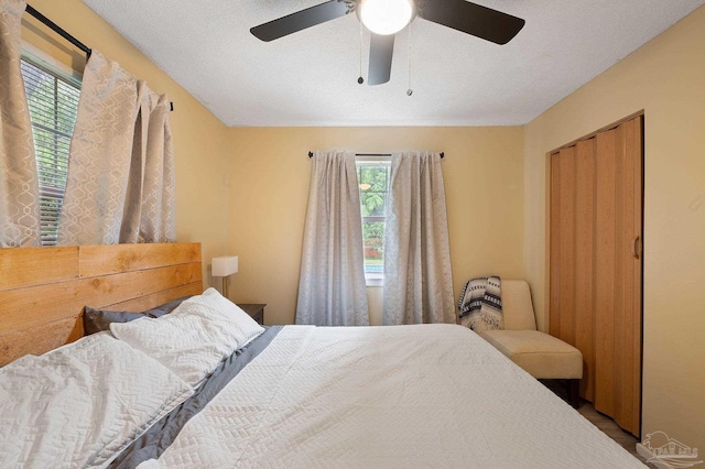 bedroom with a textured ceiling, ceiling fan, and a closet