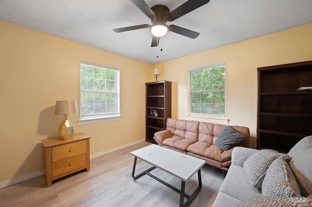 living room with ceiling fan, a textured ceiling, and light hardwood / wood-style flooring