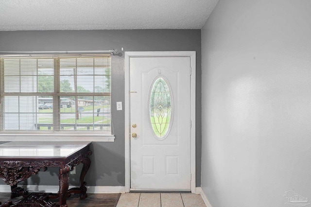 entryway featuring light tile patterned flooring and a textured ceiling